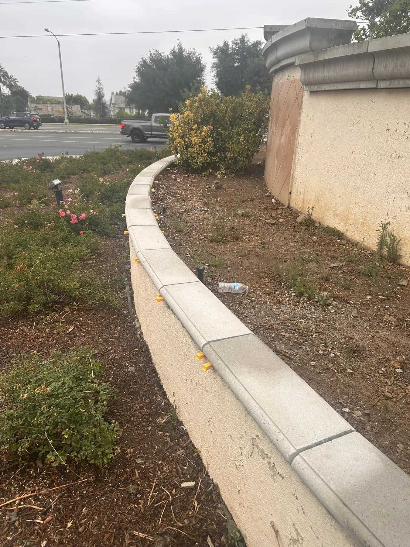 Precast concrete curb wall along a landscaped commercial street frontage