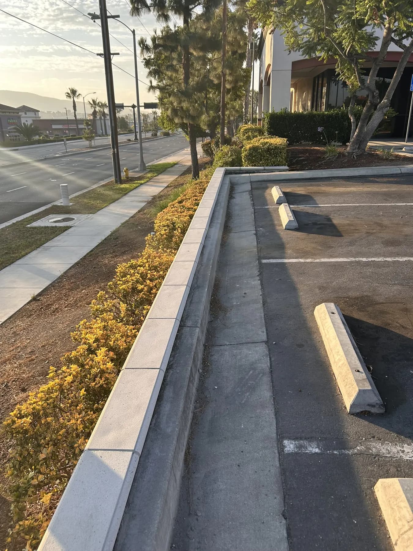 Precast capped block wall along a commercial sidewalk and parking lot