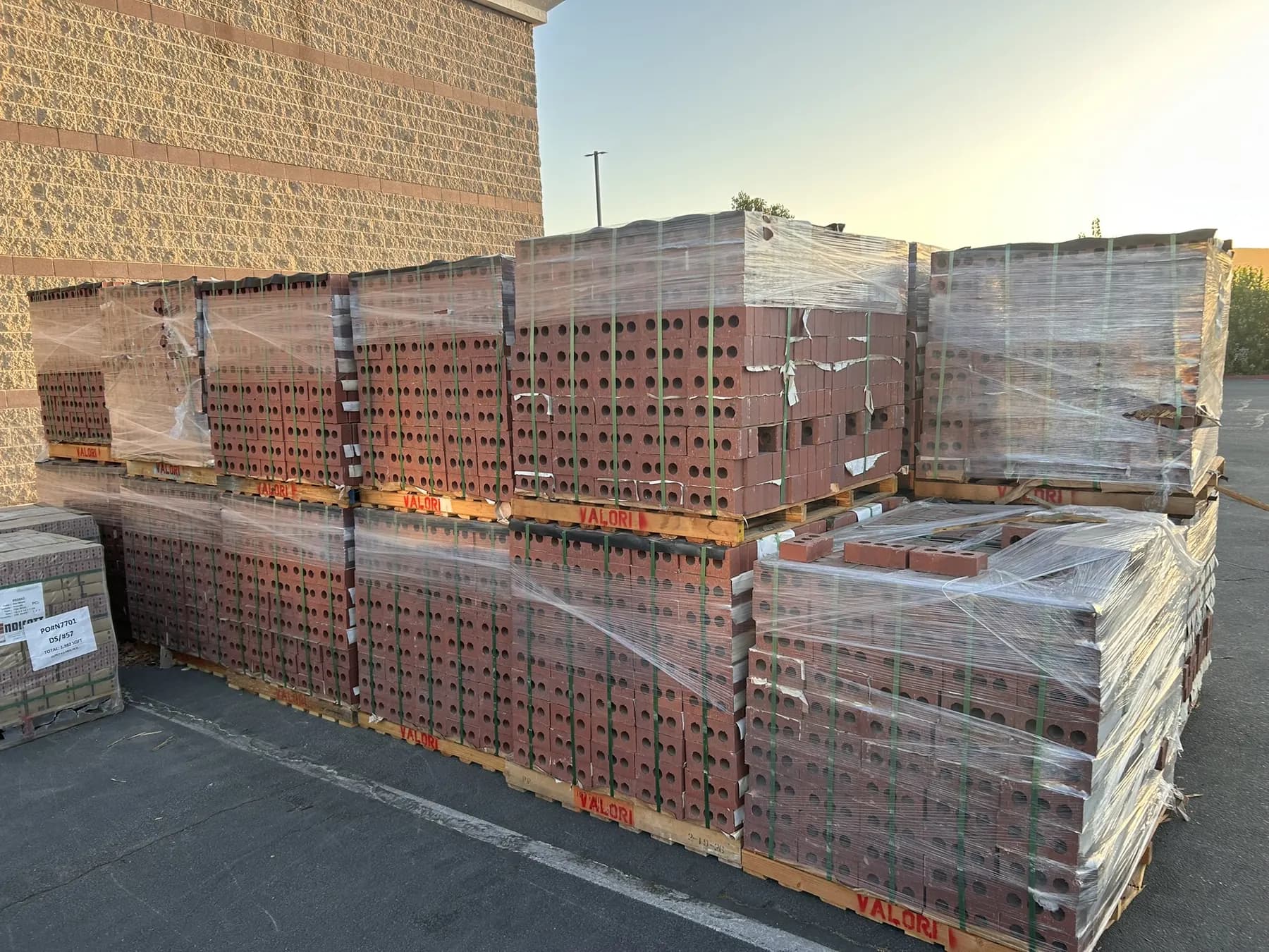 Pallets of brick staged for installation outside a commercial building