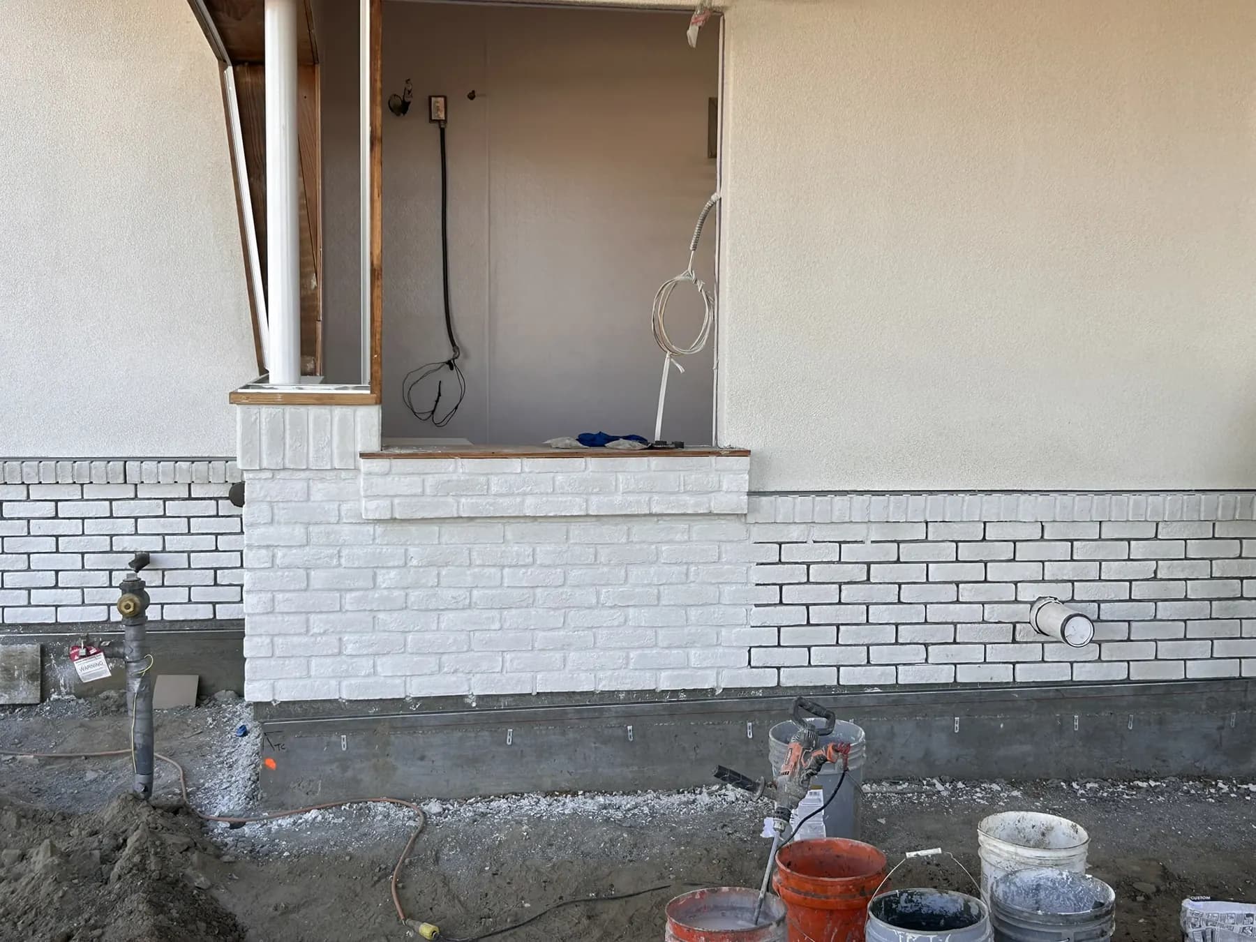 Painted brick wainscot installed along the base of a home under construction