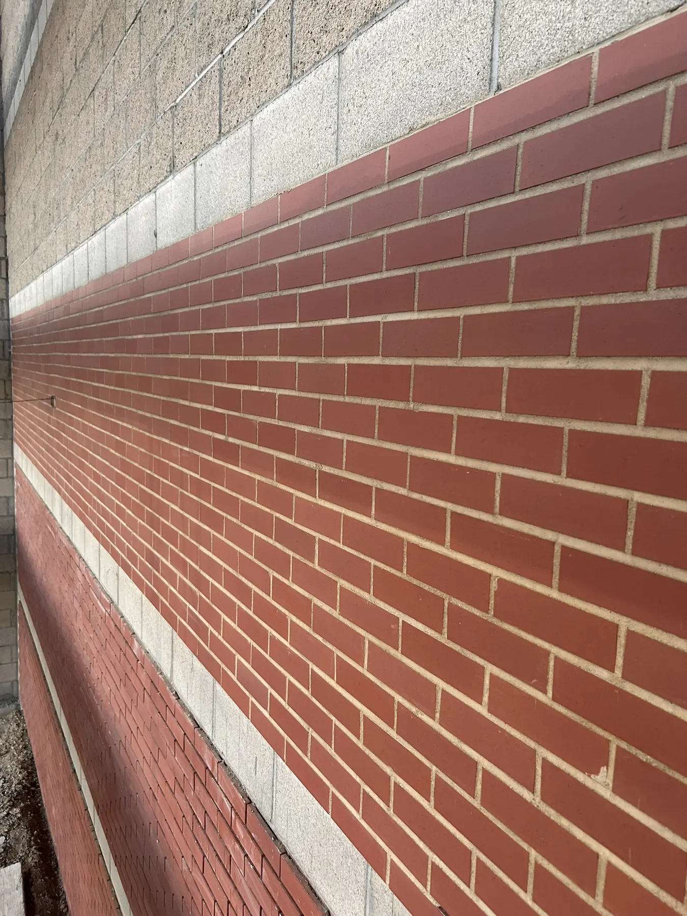 Close-up of red brick veneer with banded accent courses on a commercial building
