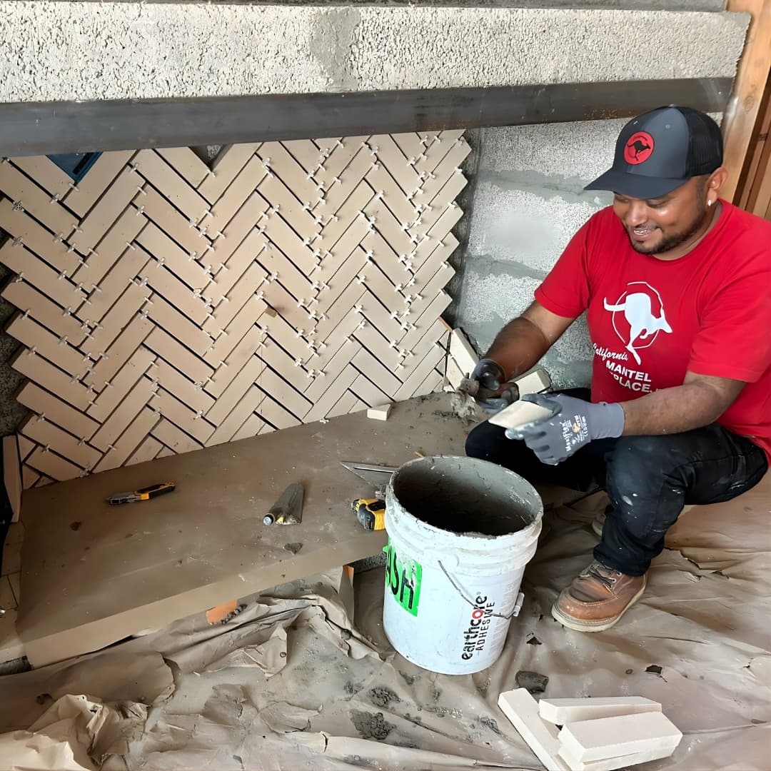 Cal Mantel mason laying herringbone tile on fireplace surround