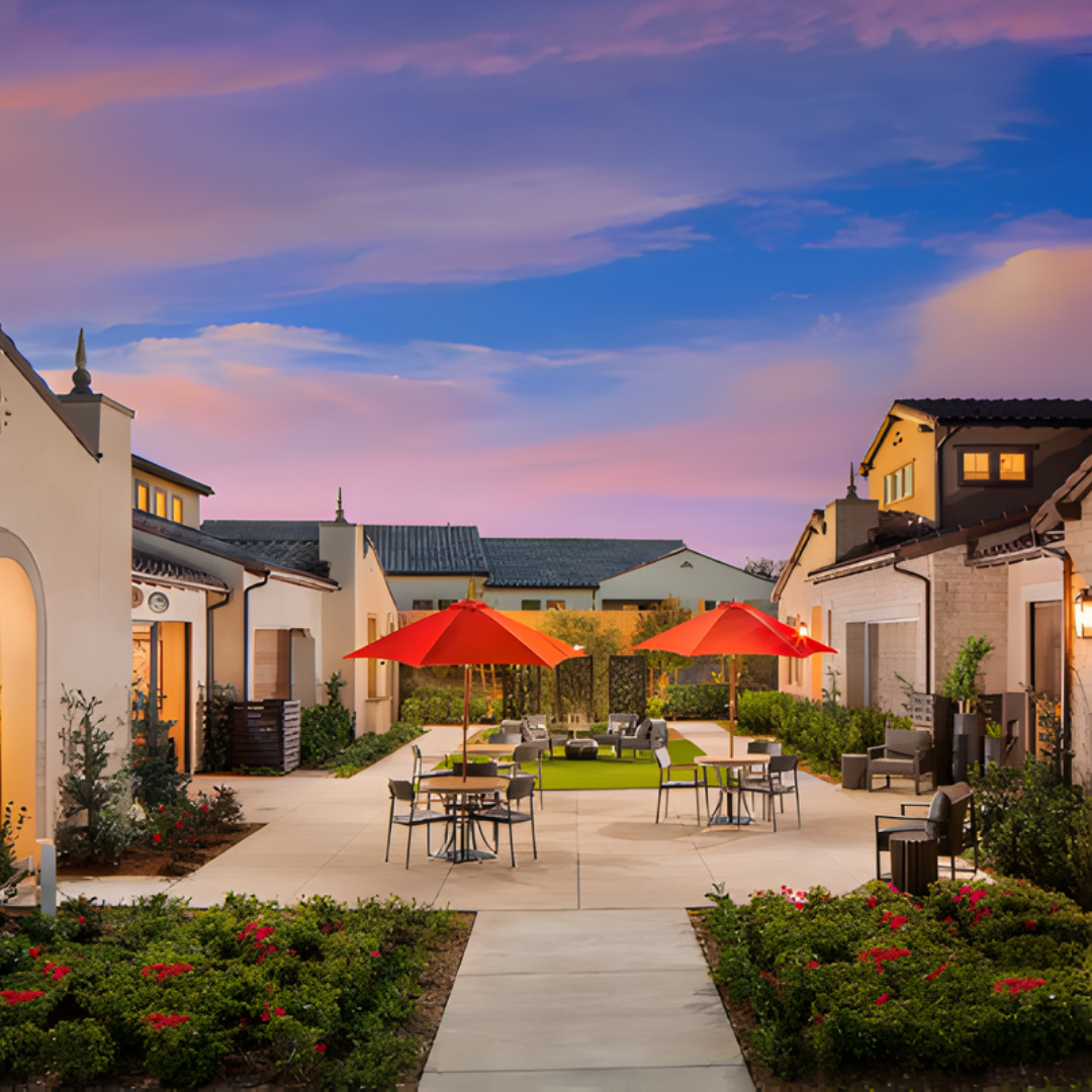 Outdoor courtyard with red umbrellas and seating at sunset